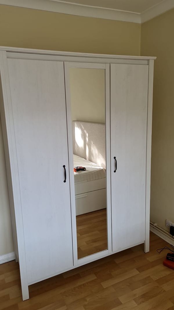 Three-door wardrobe assembled in a bedroom